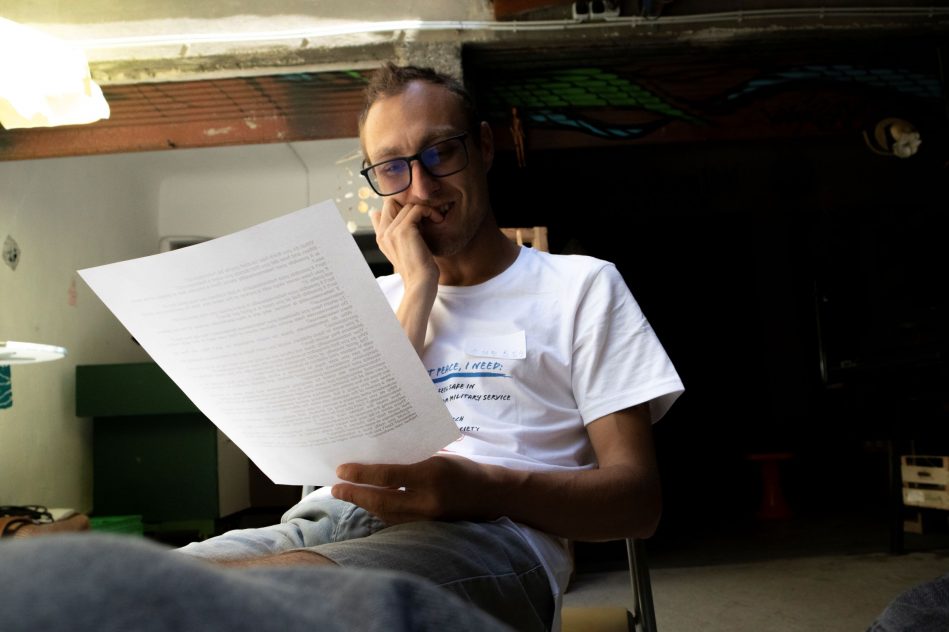 a man reading a paper while sitting on a chair